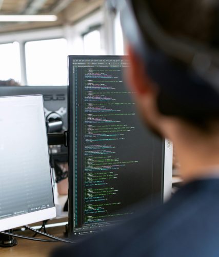 pexels-photo-3861959-3861959-1 A male software engineer working on code in a modern office setting.